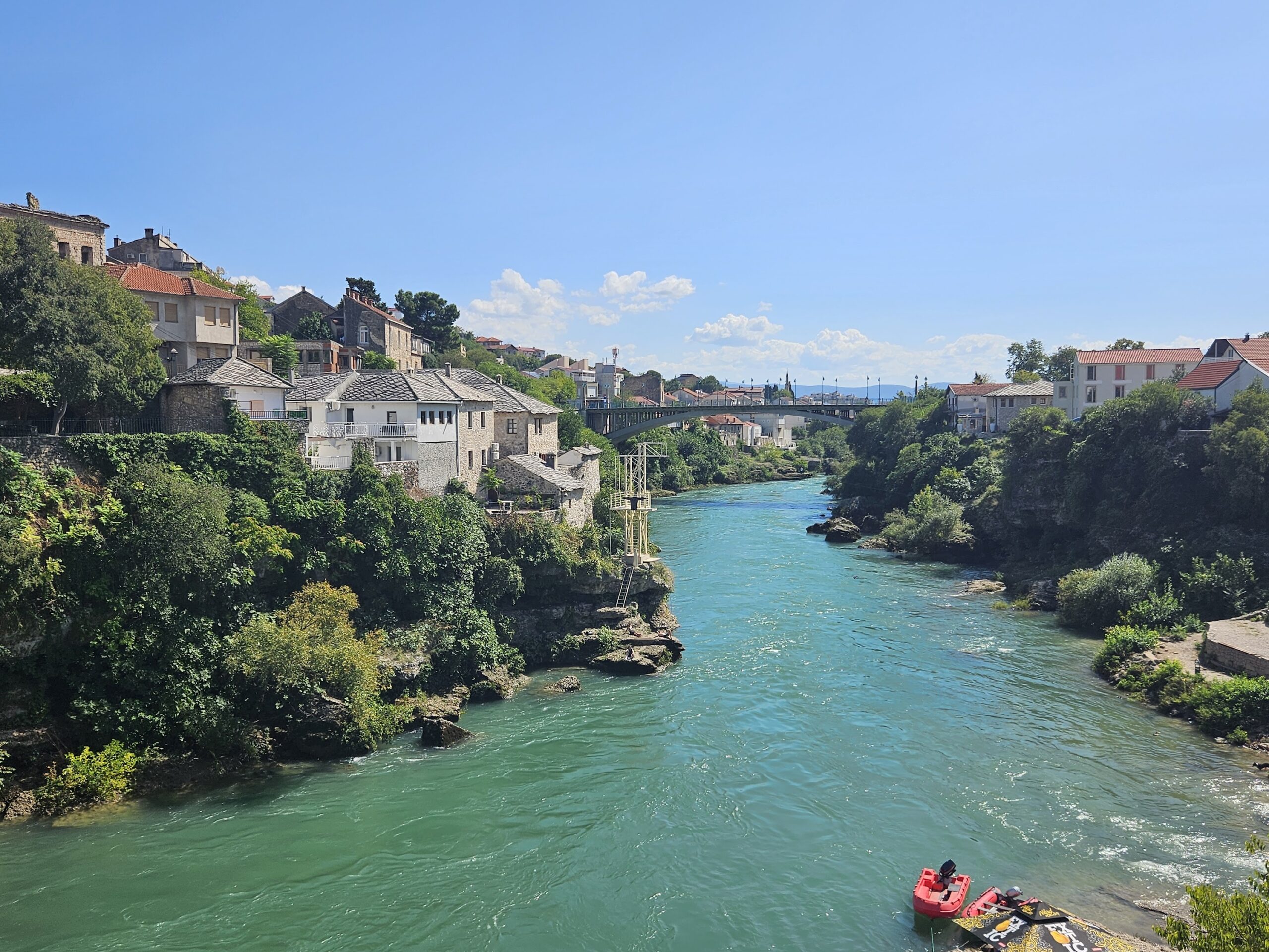 The turquoise Neretva River flowing through Mostar with stone houses on the banks