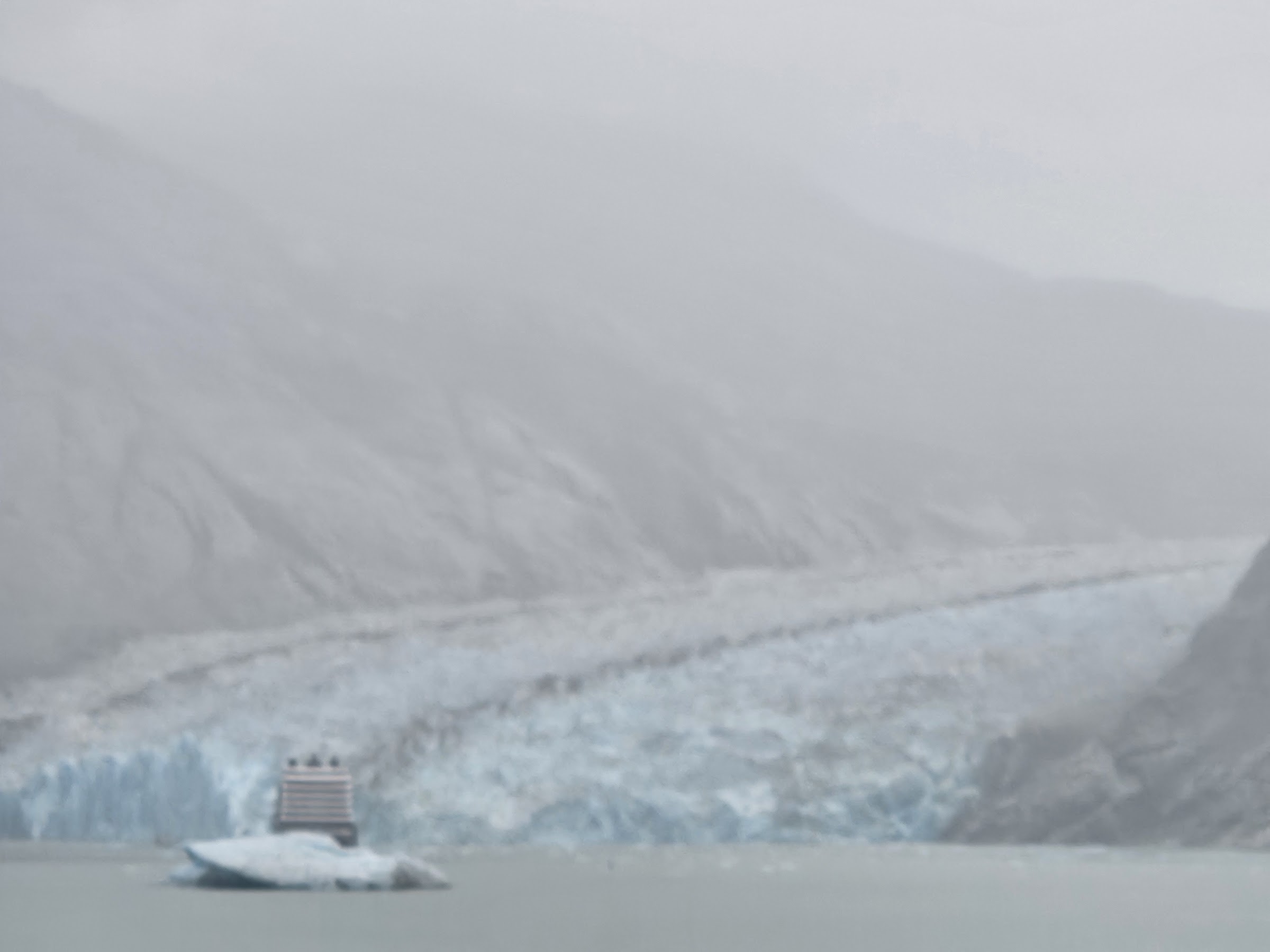 Dawes Glacier's face across the water with a small ship for scale